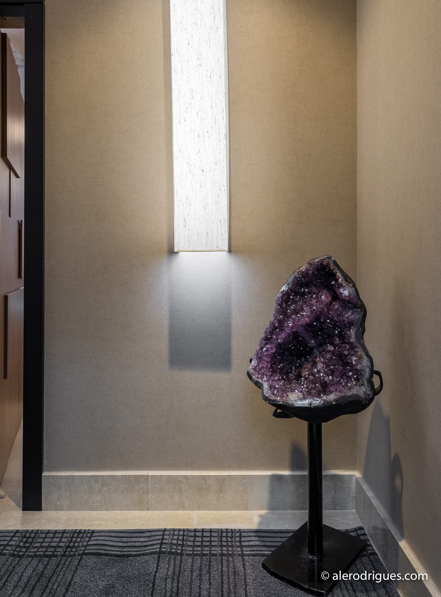 Nicho com geodo de ametista iluminado integrando personalidade ao projeto - IN.TETTO